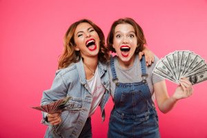 Emotional pretty two women friends holding money