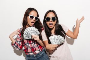 Two asian cool ladies sisters holding money.