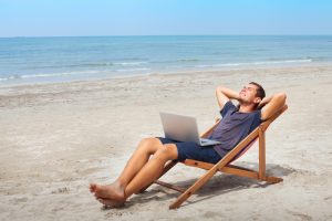 freelancer with laptop on beach