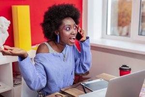 Young freelancer feeling extremely emotional receiving cal from old friend