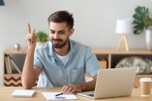 Satisfied man with raised hand thinking about good creative idea