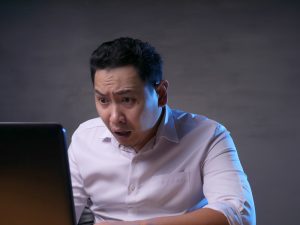 Upset Man Looking at Laptop