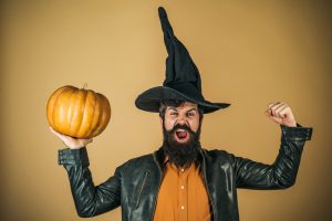 Excited happy man with pumpkin. Trick or treat. Thanksgiving seasonal cooking ingredients. Bearded man cook in Halloween hat with pumpkin.