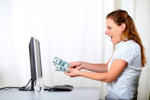 Excited blonde girl holding plenty of cash money