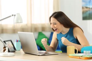 excited woman looking at computer