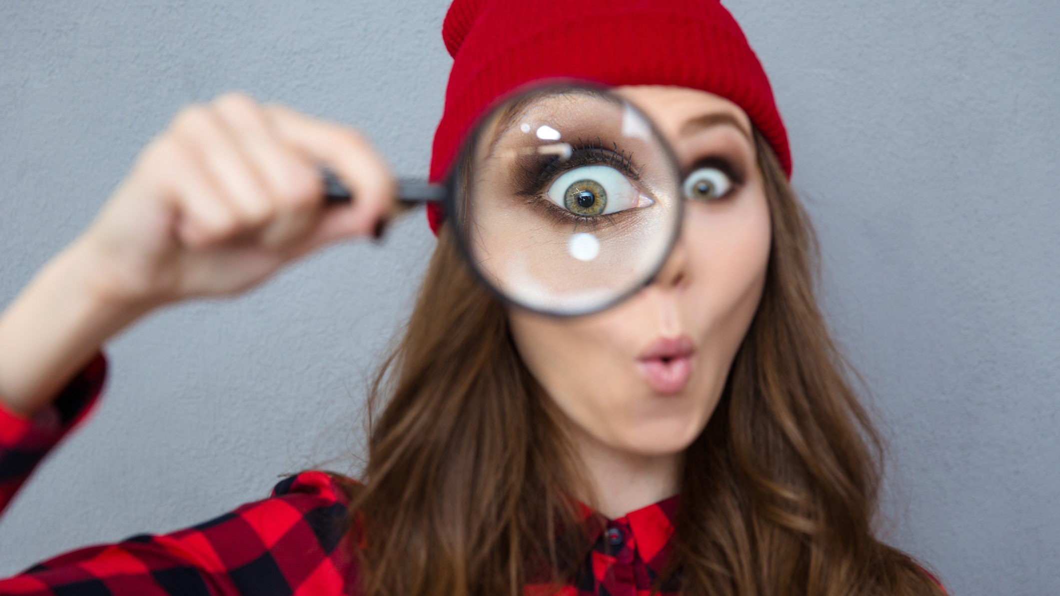 woman looking at camera through magnifying glass dreamstime_m_62137803